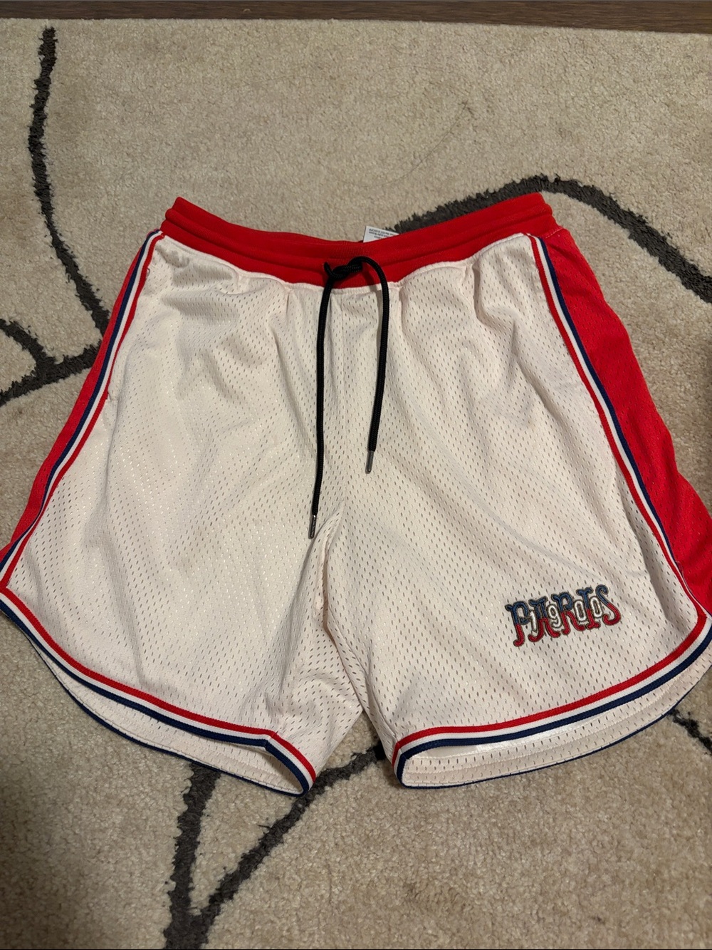 John Elliott White Mesh Athletic Shorts with Red Trim and Blue Accents